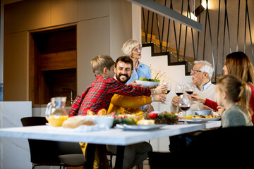 Happy family having dinner with red wine at home