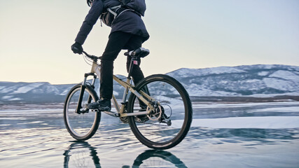 Man is riding bicycle on the ice. Ice of frozen Lake Baikal. Tee