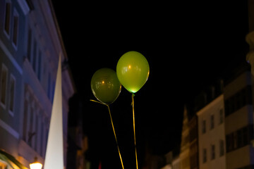 night cityscape with green party baloons