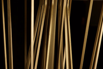 Golden sticks made of metal on a black background, high resolution - 474521120