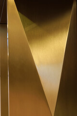 Gold-colored pillar with metal triangles, high resolution.