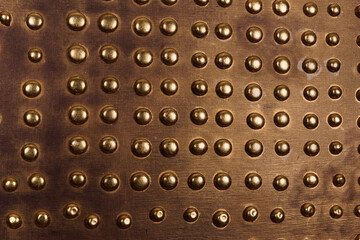 Brown wood background with metallic gold buttons all over - 474521749