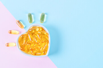 Fish oil capsules in cup on beautiful background