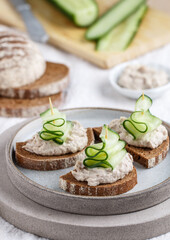 Delicious appetizer of rye bread with herring forshmak and cucumber. Canapes for a party. Christmas and New Year snacks in the form of Christmas trees. Selective focus