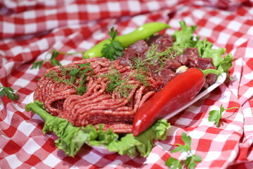 Meat varieties presented with fresh vegetables in plastic plates.