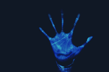 Silhouette blue color stop hand black background.