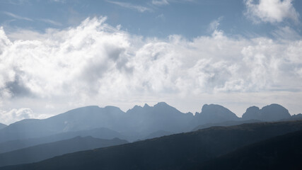 Silhouette of The Sleeping Giant peaks on Rila mountain under a cloudy, blue sky