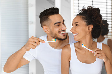 Happy Beautiful Arab Couple Making Morning Hygiene, Brushing Teeth Together In Bathroom