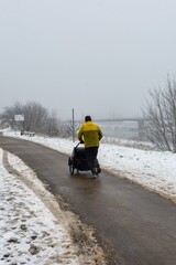 Mężczyzna biegający z wózkiem w śniegu