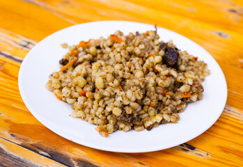 pearl barley porridge with mushrooms on a white plate