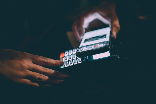 Contactless mobile payment. Payment terminal and smartphone in hands in bar
