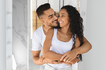 Portrait Of Young Happy Arab Spouses Embracing In Bathroom Interior