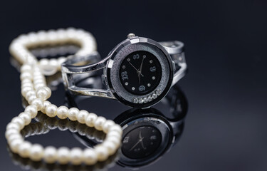 Women's watch in the original metal case and a pearl necklace