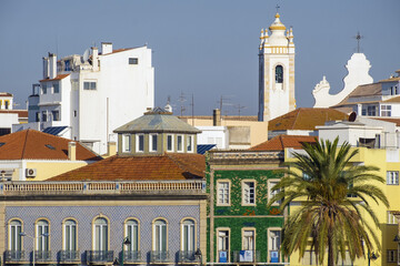 Obraz premium houses on the Ribeirinha quay and the bell tower of Church of Our Lady of Conception in Portimao, Algarve, Portugal