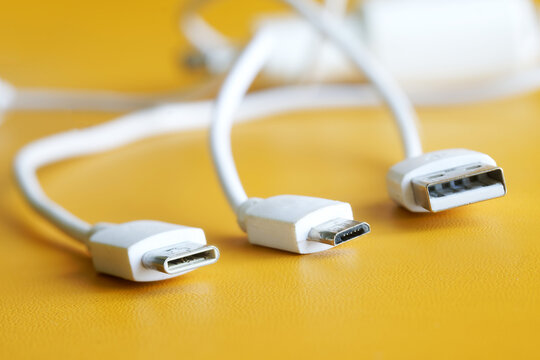 Comparison of three types of USB connectors. USB Type-A, Micro USB and Type-C. Yellow background. Macro. Selective focusing. Free space for an inscription