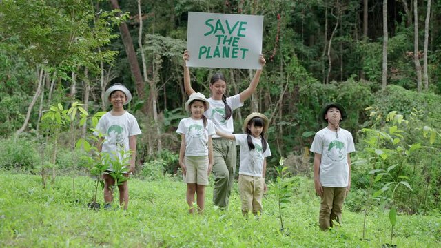 Children join as volunteers for reforestation,children holding up signs to save the planet, earth conservation activities to instill in children are patient, selfless and loving nature.
