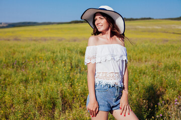 portrait of a beautiful woman in a hat with brimming in nature