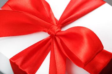 Red bow on a gift made of fabric on a white background