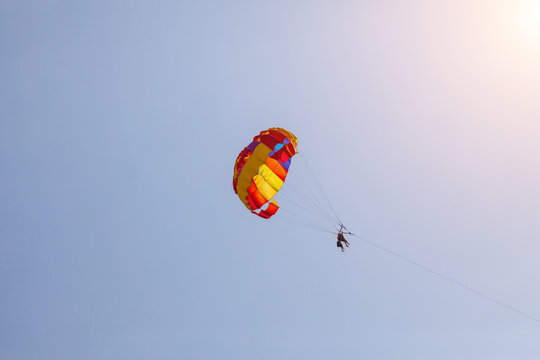 Tourists fly over the sea and the beach on a parachute. Sport and recreation for tourists in turkey