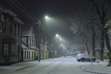 Prowincjonalne miasteczko w zimową śnieżną noc. - obrazy, fototapety, plakaty