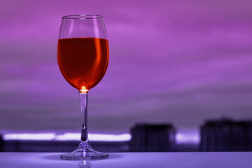 One glass of red wine on a table in a restaurant.