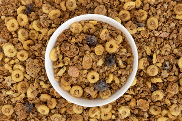 crunchy granola in bowl on muesli background
