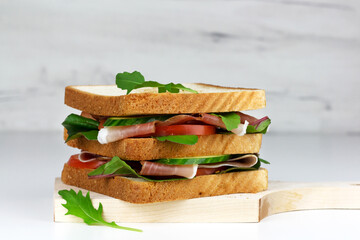 Club sandwich with spanish hamon or italian proscuitto, vegetables and greens