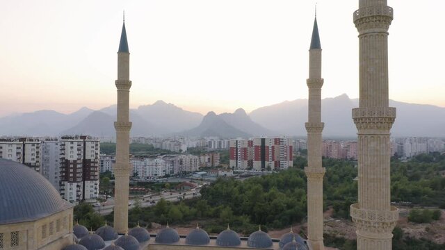 Manavgat Mosque in the Antalya region, Turkey. City buildings and mountains in the background.