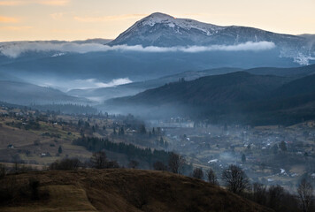 Picturesque morning above late autumn mountain countryside.  Ukraine, Carpathian Mountains, Petros top in far. Peaceful traveling, seasonal, nature and countryside beauty concept scene.