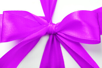 Pink bow on a gift made of fabric on a white background.