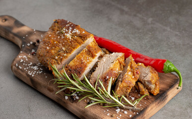 Roasted pork with spices on wooden cutting board