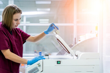 Laboratory assistant works with microwave hybrid tissue processor at the modern laboratory.
