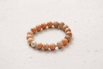 Sun stone bracelet. Bracelet made of stones on hand from natural stone Sun stone. Bracelet made of natural stones. Handmade jewelry. Handmade bracelets on light modern background