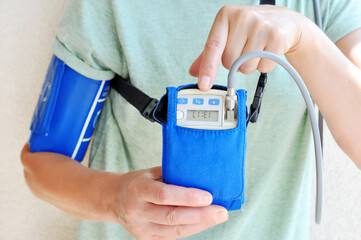 Woman wearing holter monitor device for daily monitoring of an electrocardiogram. Health care and...
