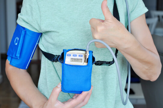 Woman wearing holter monitor device for daily monitoring of an electrocardiogram. Health care and disease prevention.the Patient shows the result