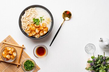 Traditional Chicken Porridge rice gruel in bowl shot on white background with negative space.
