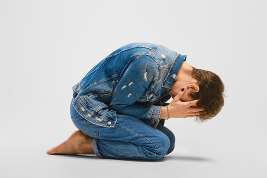 Desperate young man kneels on the floor