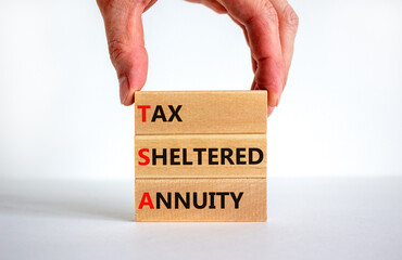 TSA, tax sheltered annuary symbol. Concept words TSA, tax sheltered annuary on wooden blocks. Beautiful white background, businessman hand, copy space. Business and TSA, tax sheltered annuary concept.