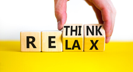 Relax and rethink symbol. Businessman turns cubes and changes the word 'relax' to 'rethink'. Beautiful yellow table, white background. Business, relax and rethink concept. Copy space.