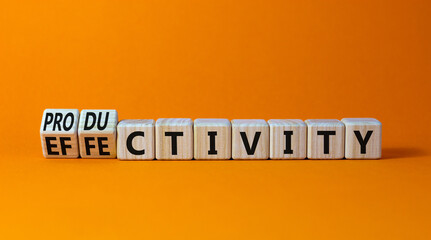 Effectivity and productivity symbol. Turned wooden cubes and changed the word productivity to effectivity. Beautiful orange background, copy space. Business, effectivity and productivity concept.