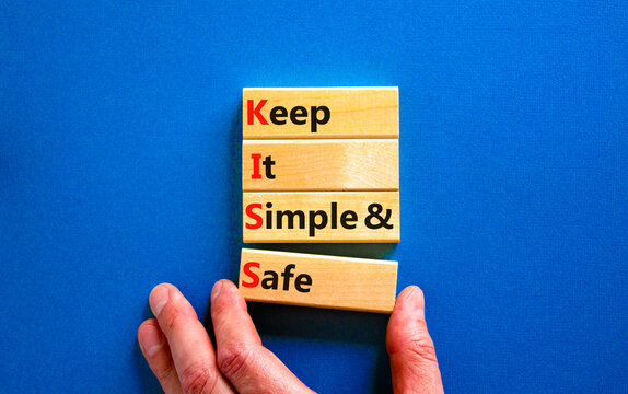 KISS keep it simple and safe symbol. Concept words KISS keep it simple and safe wooden blocks. Beautiful blue table, blue background. Business and KISS keep it simple and safe concept. Copy space.