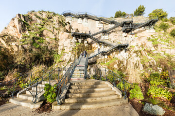 Magnifique escalier urbain à flanc de falaise dans l'ancienne carrière Miséry transformée en jardin. Jardin extraordinaire de Nantes. - obrazy, fototapety, plakaty