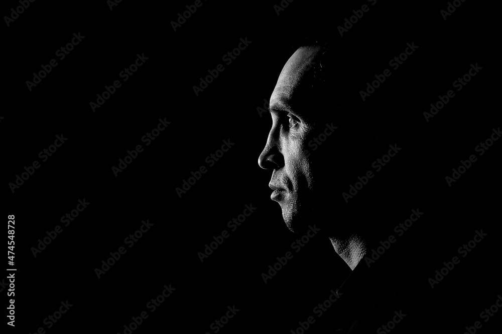 Wall mural Mature man in a shirt in profile on a dark background