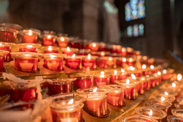 Many candles burning at night. Abstract candles background. Many candle flames glowing on dark background. Close-up.