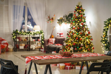 Christmas home room with Christmas tree and festive bokeh lighting, on background kitchen decorated for holiday . Christmas and new year interior-blurred background. Lots of lights that glow in dark.