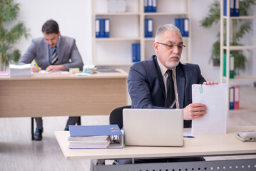 Obraz premium Two male employees working in the office