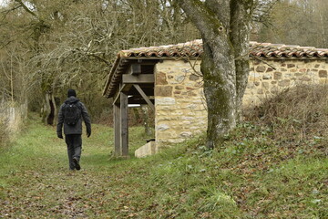 Promeneur solitaire marchant pour se diriger vers le lavoir communal de Puycelsi