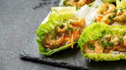 Lettuce wraps loaded with Spicy prawn, shrimp and rice vermicelli noodles, Asian style finger party food
