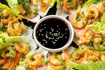 Lettuce wraps with Spicy prawn, shrimp and rice vermicelli noodles on plate. Asian style finger party food