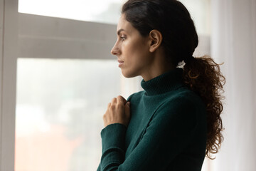 Sad millennial woman look in window distance thinking pondering of life problems. Unhappy young...
